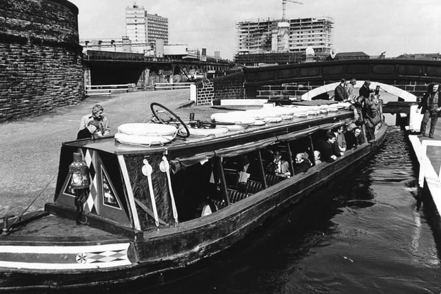 Members of the Leeds City Council aboard a barge travelling on the Aire and Calder Navigation Canal. They are seen here negotiating a city centre lock near Victoria Bridge.
