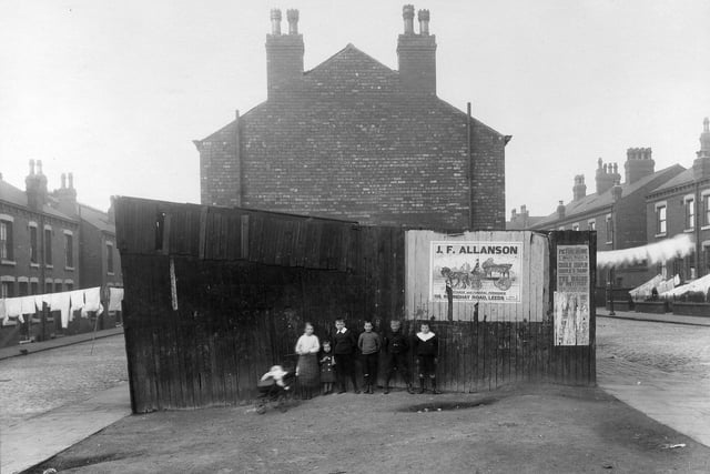 A group of children pose for the camera in front of an outside toilet block at the end of a row of terraced housing in Harehills. Arundel Street is to the left while Gledhow Road is on the right