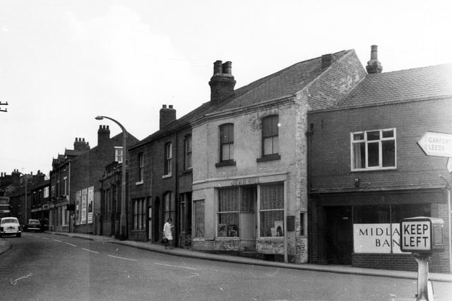 Cross Hills, close to the junction with High Street in Kippax.  The light coloured building with the net curtains at the ground floor windows is Jean Hill, ladies hair stylists.
