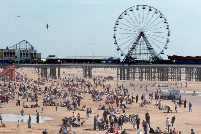 The wheel on Central Pier towers above a crowded beach