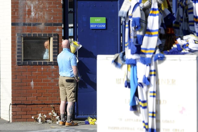 Leeds United flags at the foreground of flowers laid in memory of Chris Loftus and Kevin Speight. Picture by Simon Hulme.