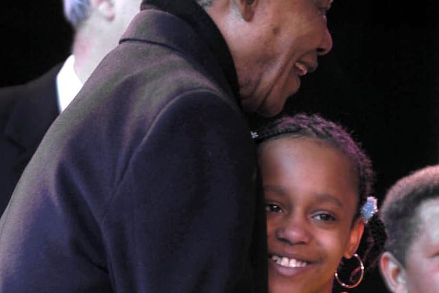Nelson Mandela receives a hug from one of the Childrens Choir that welcomed him on stage.