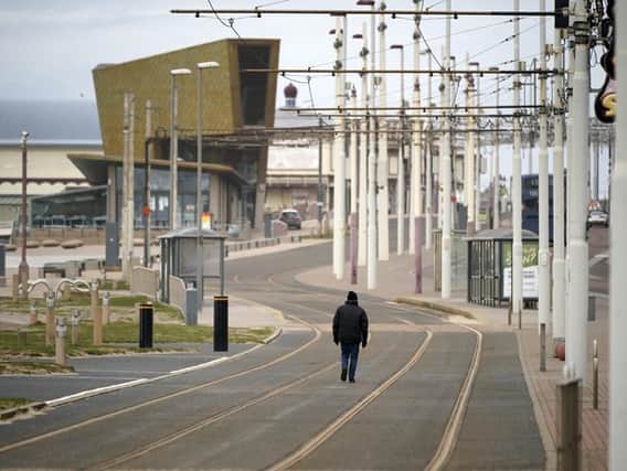 A lone man walks along Blackpool's Golden Mile as holiday makers, locals and businesses observe the pandemic lockdown and stay home (Photo by Christopher Furlong/Getty Images)