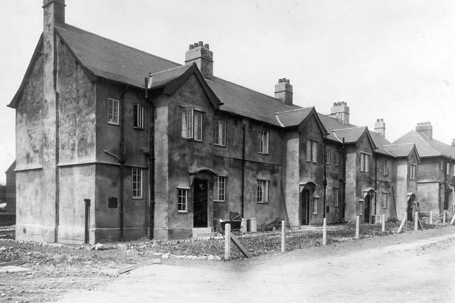 Newly-built council houses on the Meanwood estate with concrete and wire fences. One has a perambulator outside.