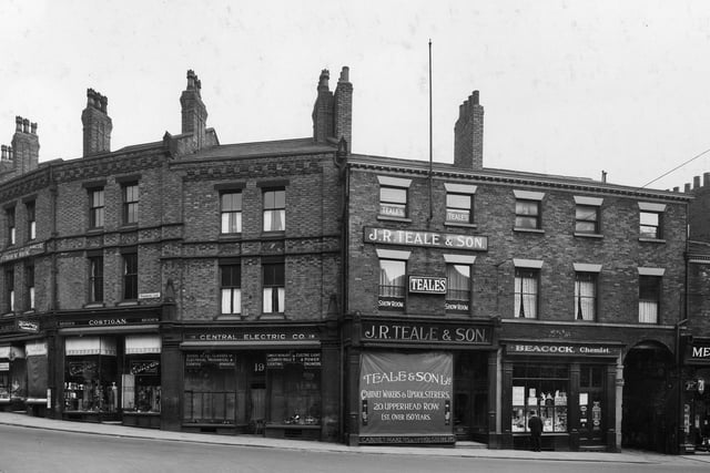 Shops on Upperhead Row. Pictured, right to left, is entrance to Osborn Court with Joseph Beacock Chemist, J R Teale and Son, cabinet makers & upholsterers next door, and Central Electric Company on the junction with Woodhouse Lane.