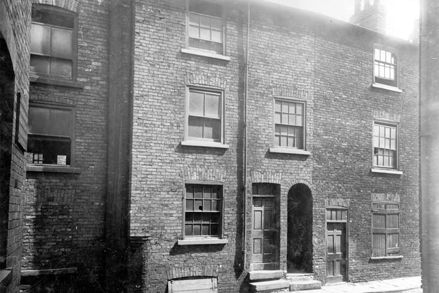 A row of three-storey terraced buildings on Prussia Street, which ran between Lady Lane and Nelson Street. The brick-built buildings look to be unused with some smashed and boarded up windows