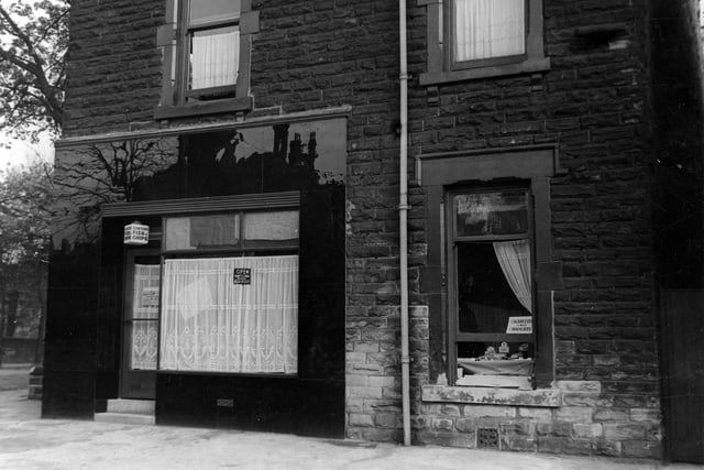 Cantors Fish & Chip Shop on the corner of Chapeltown Road and Harehills Avenue. House next door appears to be selling cigarettes and chocolate from an open window.