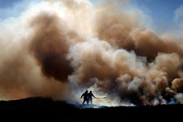 Gamekeepers burn the peat on Westerdale Moor, near Castleton, on the North York Moors. March 2003.