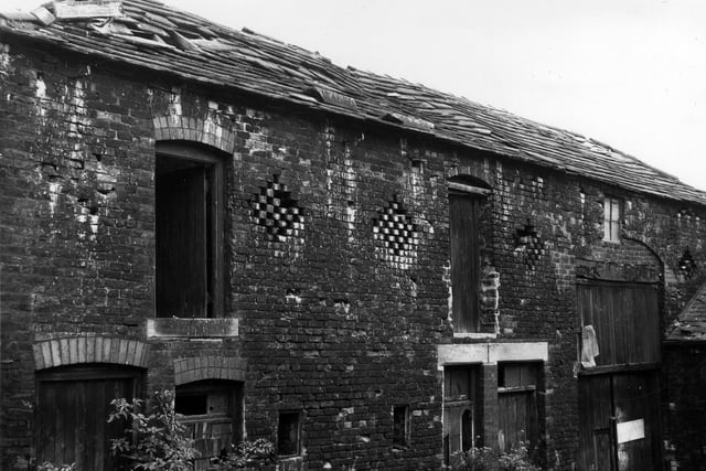 A view showing the rear of dilapidated cottages and outbuildings belonging to Ebor Farm, adjoining Ebor House, on Middleton Road. The buildings seen here have since been demolished, as has the farm, but Ebor House remains standing.