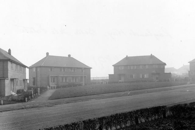 This view shows houses Nos.19-29 on the South-East side of Rayland Way. Basic layout with a grassy area between a semi-circular row of houses.