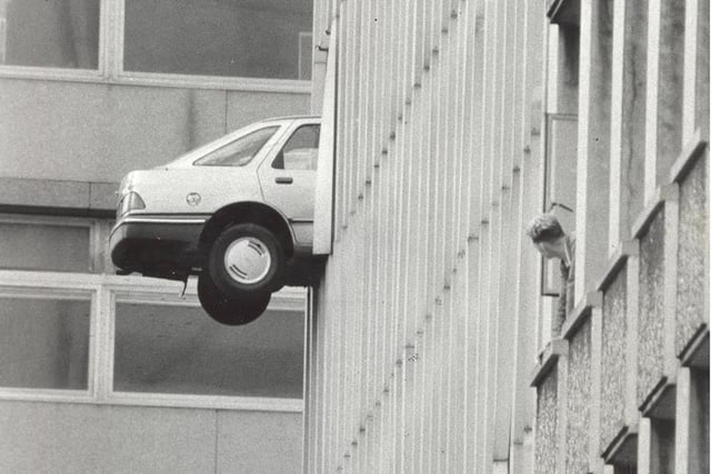 An onlooker gets a close-up view of a car that had run through the wall of the Greek Street multi storey car park in Leeds.