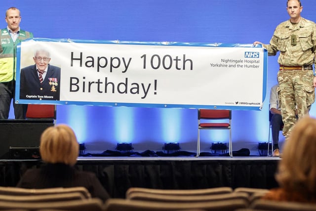 Guests hold up a sign wishing a Happy 100th Birthday to Captain Tom Moore as he and his daughter Hannah Ingram-Moore speak via videolink at the opening of NHS Nightingale Hospital Yorkshire and Humber in Harrogate.