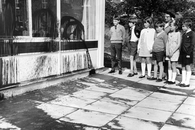 Pupils of Greenhill County Primary Junior School look at tar that has been sprayed on their new school building.