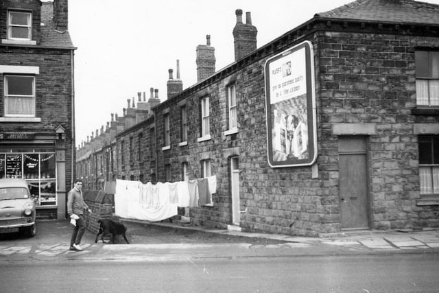 A view of Back Fenton Street. A line of washing hangs across the unmade access road. To the left is Moss's grocers and general store on Bradford Road.