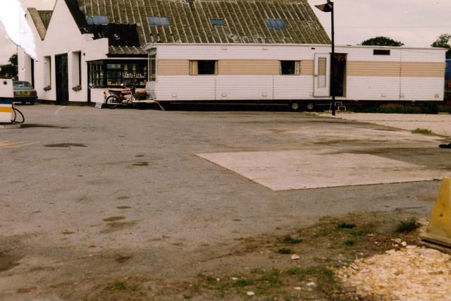 A mobile home outside Tadcaster Way Service Station, proposed to be turned into a cafe. The service station building is in the background with petrol pumps on the left.