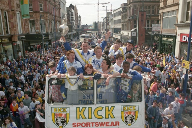 Gary McAllister holds aloft the First Division trophy as the open top bus makes its way through the city centre.