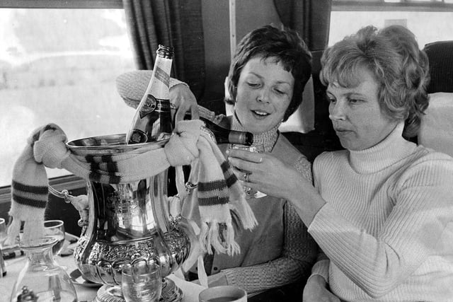 The players wives toast FA Cup glory with a glass of champagne on the train home.