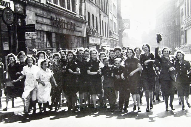 Revellers let their hair down outside the Navy, Army and Air Force Institutes club in Albion Street on VE Day.