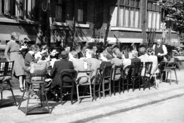 The adults of Talbot View in Burley are seated around a long table set up in the street for a party in celebration of VE Day.