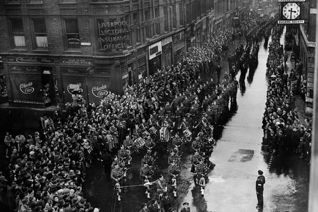 Looking from The Headrow down Albion Street as the Victory Parade passes. Over 2,000 members of auxiliary units took part. In spite of the rain dense crowds gathered to watch and celebrate.