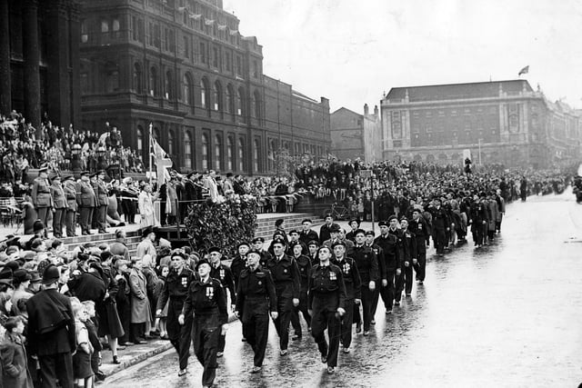 Victory Parade, marching past Leeds Town Hall is a contingent of Air Raid Wardens, the Lord Mayor Charles Walker is taking the salute. The parade had over 2,000 auxiliary personnel taking part.
