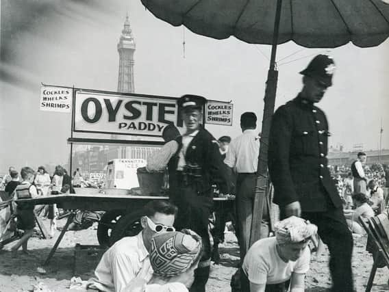 An oyster and cockle seller on the beach in the 1950s.