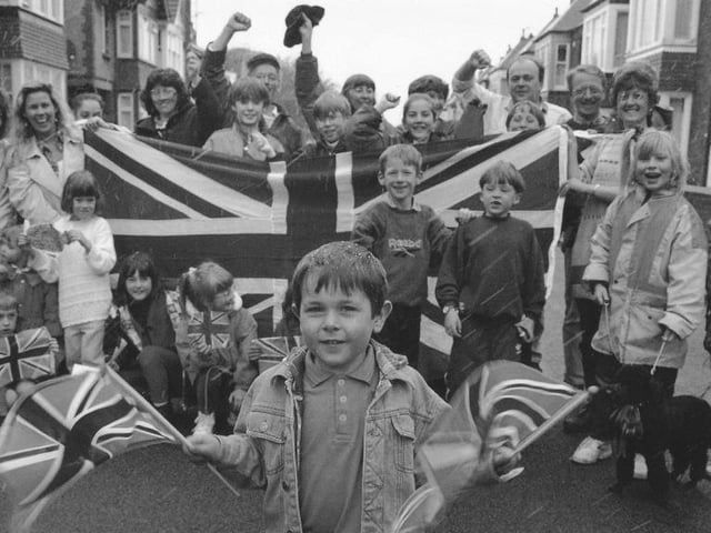 Thomas Davies, front, waves the flags at the Oakville Avenue street party.