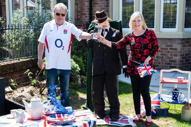 Susan and Michael Clifford enjoy a toast with a very special guest - a scarecrow Winston Churchill - at a Bispham street party
