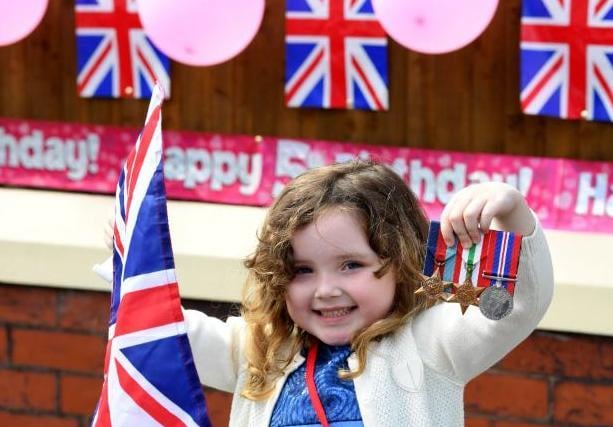 Ruby Whittle celebrates her 5th birthday and VE Day by proudly displaying her great, great, great uncle's war medals in Chorley