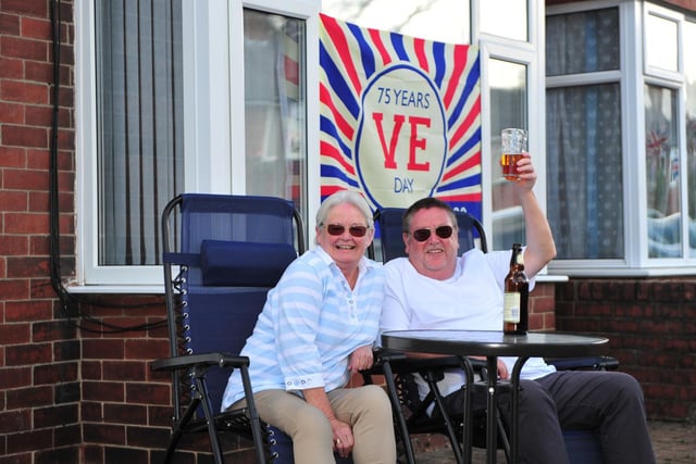 Pictured are Gill and Kevin Wood in their garden surrounded by bunting and a VE Day flag at the St Johns Drive street party.