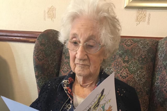 A resident at The Sands care home looks at a VE Day card.