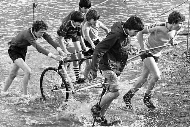 One of the scout troops emerge from a watery section with their chariot along the cross country course at Bispham Hall, Billinge, on Saturday 20th of October 1979. The scouts had to build and then race the chariots and this was the second year of the event.