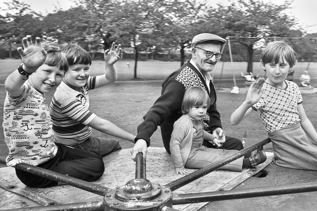 A Grandad and youngsters have a twirl on the roundabout in Alexandra Park, Newtown, on Wednesday 2nd of August 1978.
