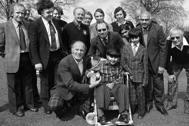 Boxing legend, Henry Cooper, presents an electric wheelchair to local lad, Yogesh Patel, before playing golf at Deanwood Golf Club, Up Holland, on Sunday 22nd of April 1979 as part of his charity golfing rounds to raise money for wheelchairs for disabled children.