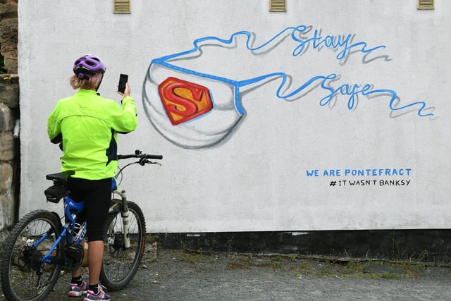 A cyclist stops to take a photo of a NHS mural on the side of the Fitness Base Gym in Pontefract.