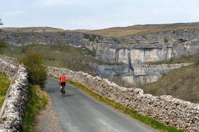 A lone cyclist rides up the Cove Road past Malham Cove on Good Friday during the coronavirus lockdown which saw the usual bank holiday hotspts deserted.