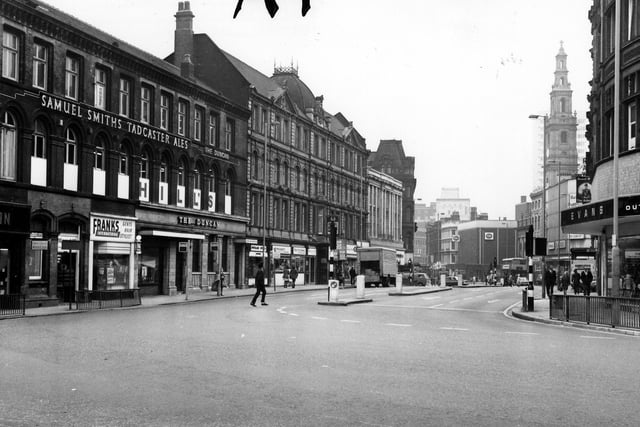 Duncan Street looking west from the junction with New Market Street. On the left are Frank's Gents Hair Stylist and The Duncan pub. Visible on the right are Evans Outsize Clothes then Holy Trinity Church and C & A further along on Boar Lane.