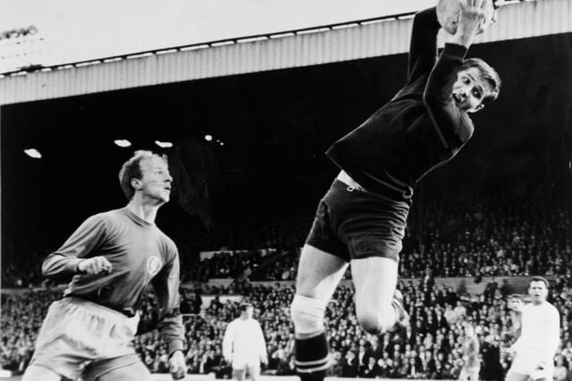 Ferencvaros goalkeeper Istvn Gczi holds on to the ball in mid-air as Jack Charlton looks on.