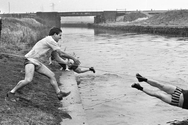 Heading for splash down during a tug-o-war contest between the Stork Hotel, Marsh Green, and the Victoria Hotel, Up Holland, over the canal on Woodhouse Lane, Springfield, on Sunday 3rd of February 1980.  The teams raised 200 for Wrightington Hospital Children's Ward.