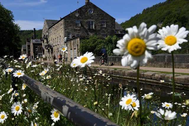 People ride their bikes along the Rochdale canal at Hebden Bridge, in the Bank Holiday sunshine