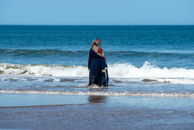 A woman paddles in the sea at Whitby beach