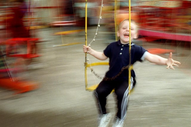 Three-year-old Tommy Jones from Preston, enjoying himself on the swings during a visit to the fun fair on Moor Park in Preston in 1999