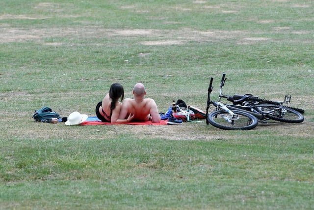 A couple relax in Roundhay Park after a bike ride.