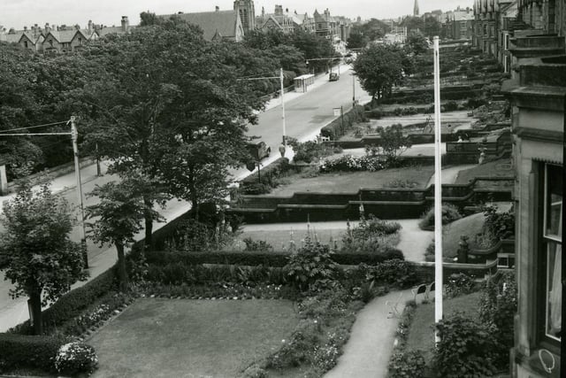 A view from the window of a house on Clifton Drive North looking Towards St Annes Square. On the left are the trees in Ashton Gardens with St Annes on Sea United Reform Church beyond. In the far distance is the Spire of The Drive Methodist Church. Traffic was light in this 1950s photograph.