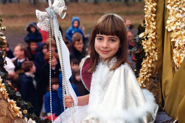 The little girl, in her fancy costume, is seated on the float entered by Lewis's department store depicting a steam engine of the American West. She is wearing a  sequinned, layered net skirt and a silver cape trimmed with swansdown.