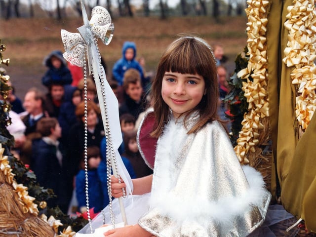 The little girl, in her fancy costume, is seated on the float entered by Lewis's department store depicting a steam engine of the American West. She is wearing a  sequinned, layered net skirt and a silver cape trimmed with swansdown.
