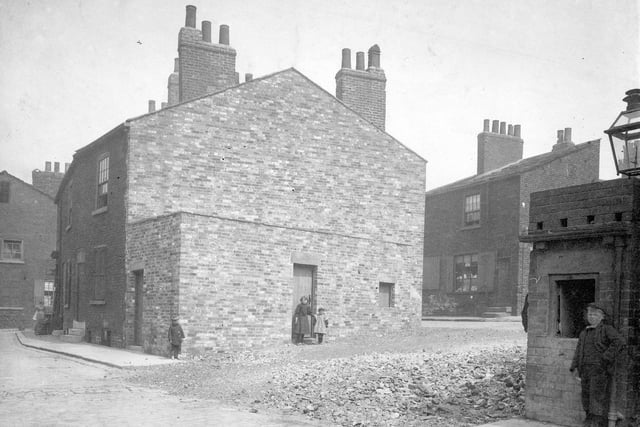 Terraced houses in Brass Street and Copper Street. Children in doorways. Top of gas lamp can be seen to right of photo.
