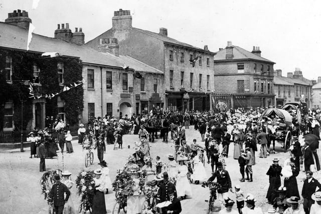 Wetherby Market Place looking very festive in celebration of the Diamond Jubilee of Queen Victoria. Townspeople are decked out in their best clothes and many are wheeling their flower decorated bicycles.