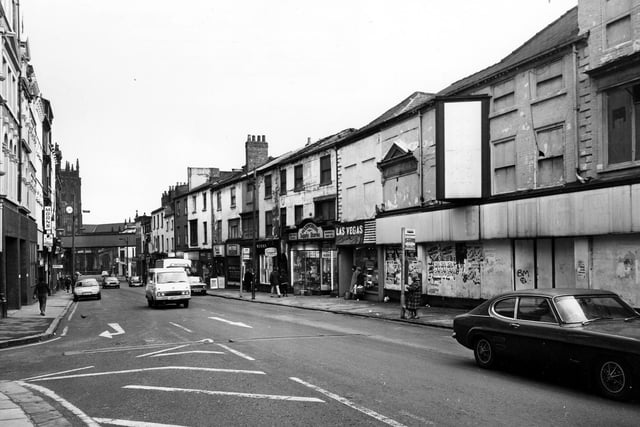 Kirkgate with the junction with New York Street on the left. Shops on the right include Las Vegas Amusements, Woodworkers Supply Stores D.I.Y., Derby Bar Cafe and Kirkgate Anglers Fishing Tackle.