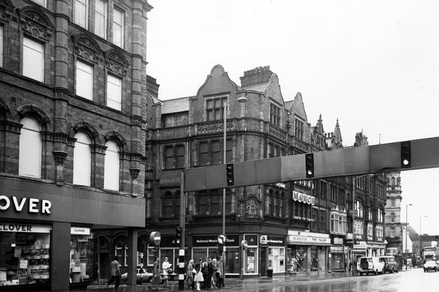 Looking across Vicar Lane to the junction with Sidney Street, Showing from left, Clover department store, National Westminster Bank, March the Tailor, Photomarket and Bargain Records.